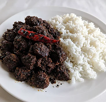 Beef kala bhuna with a roasted red chili, next to white rice