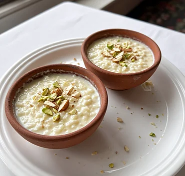 Firni rice pudding with pistachios and almonds in two clay bowls