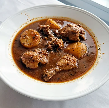 Chicken curry with potatoes in a white bowl