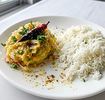 Aloo bhorta with onion, coriander and roasted red chili, next to white rice